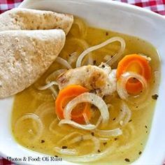 a white bowl filled with soup and tortilla on top of a checkered table cloth