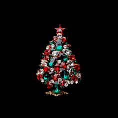 a small christmas tree with red, green and white jewels on it's sides