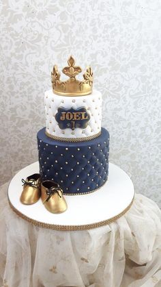 a three tiered cake with blue and white frosting, topped with gold shoes