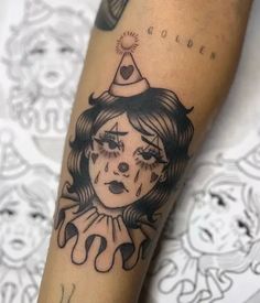 a woman's arm with a black and white drawing of a clown on it