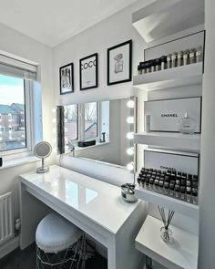 a room with a vanity, stools and mirror in the corner next to a window