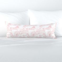 a bed with white sheets and pink pillows