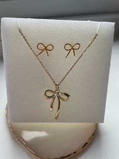 Very cute gold bow necklace and stud earring set. Chain is 40cm dainty and delicate 925 sterling silver water wave chain. Large gold bow charm is zinc alloy 2cm x 2.6cm. Bow studs are 925 sterling silver gold colour. Simple and dainty gold bow set of jewellery.