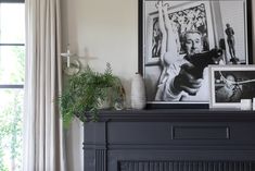 a living room filled with furniture and pictures on the wall above a fireplace mantel