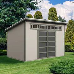 a large gray shed sitting on top of a lush green field