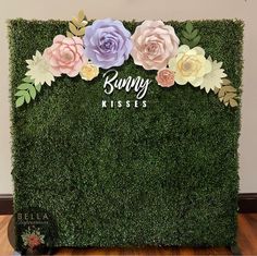 a moss wall with flowers and the words bunny kisses on it