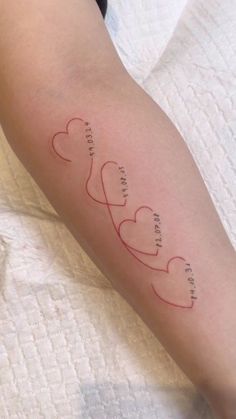 a woman's arm with three hearts and the words, love is in the air