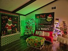 a living room decorated for christmas with dr seuss and grin's chalkboard