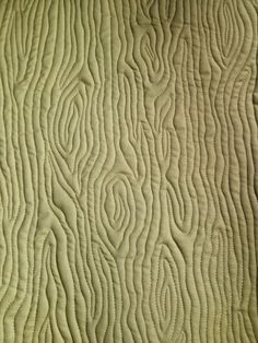 a close up view of a quilted material with wavy lines and curves on it