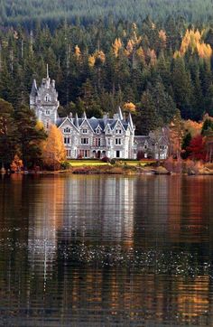 a large white house sitting on top of a lake