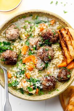 a bowl filled with meatballs and rice next to some toasted bread on the side