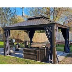 an outdoor gazebo with curtains and hot tub