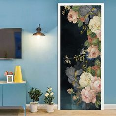 an open door in a blue room with flowers painted on the wall and a television