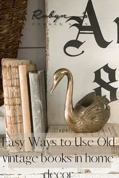 an old fashioned book shelf with books and a swan statue on it, next to some vintage books