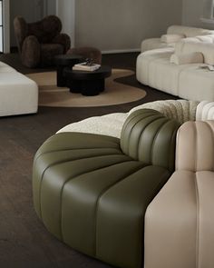 a living room filled with lots of white and green couches next to each other