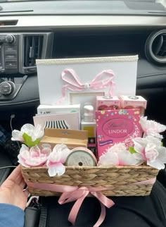 a person holding a basket filled with items in their car's dash board area