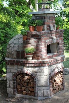 an outdoor brick oven with potted plants on top