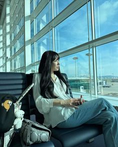 a woman sitting in an airport waiting for her luggage to be taken off the plane