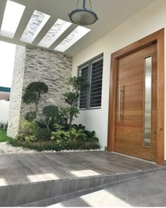 a wooden door sitting on the side of a white wall next to a planter