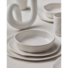 white dishes and cups are stacked on top of each other