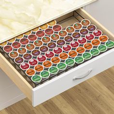 an open drawer with many different items on the drawers and one is filled with magnets