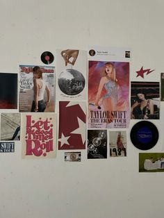 a white refrigerator covered in pictures and magnets next to a wall with various records on it