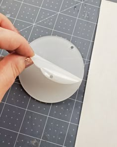 someone is cutting out a piece of paper on a table with scissors and glue in it