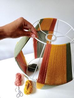 someone is working with yarn to make a lamp shade