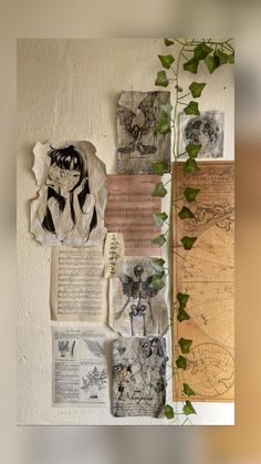 various papers and pictures are hanging on the wall next to a plant with ivy growing in it