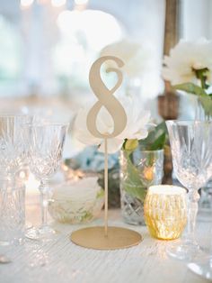 the table is set with glasses, candles and a cake topper that says 8