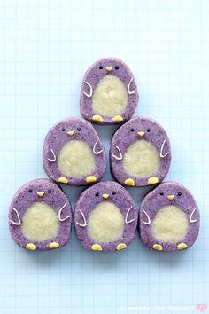 some purple and white cookies with penguins on them