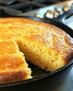 a close up of a cake in a pan on a stove top with one slice missing