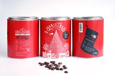 three tins with chocolate chips in front of them on a white surface, one has a christmas tree and the other has a santa's stocking hat