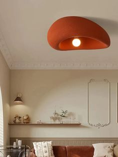 a living room filled with furniture and a large orange light fixture hanging from the ceiling