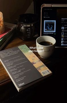 an open book sitting on top of a table next to a cup of coffee