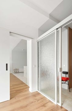 an empty room with white walls and wood flooring is seen through the glass doors