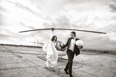 a bride and groom walking towards a helicopter on the tarmac for their wedding ceremony