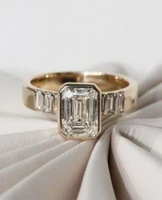 a diamond ring sitting on top of a white cloth