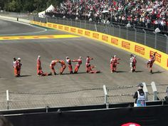 some motorcyclists are standing in front of the word love on the track