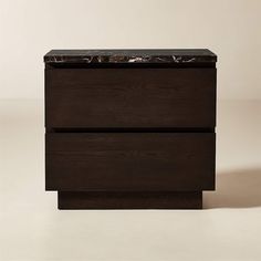 a black marble topped chest of drawers against a white background