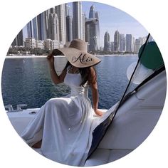 a woman sitting on the back of a boat wearing a hat