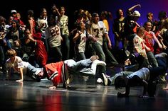 group of people on stage with one person falling to the ground in front of them