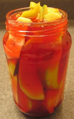 a jar filled with fruit sitting on top of a counter