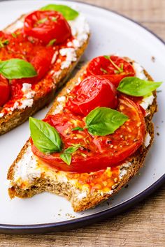 two slices of bread topped with tomatoes and basil