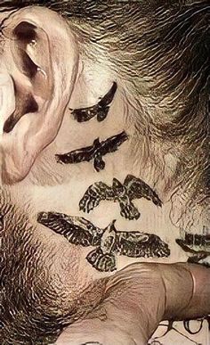 a man with tattoos on his neck and behind the ear is a bird flying in the sky