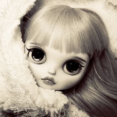 a black and white photo of a doll with big eyes