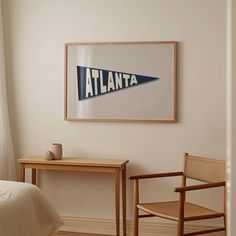 a bed room with a neatly made bed and a framed poster on the wall above it