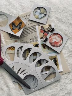 scissors are laying on top of some cut out paper and other crafting items that include butterflies