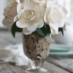 a vase filled with white flowers on top of a wooden table