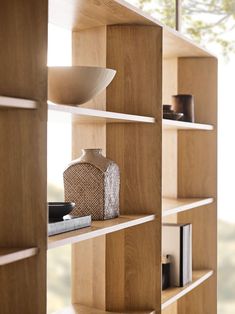 a wooden shelf filled with books and vases